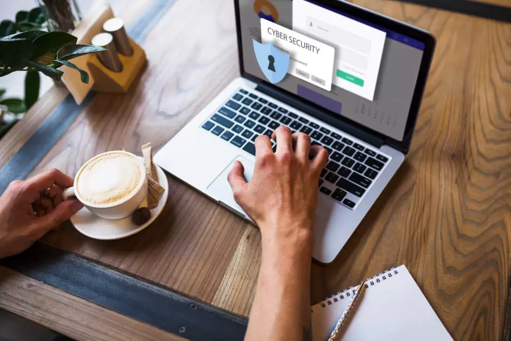 Melhor hospedagem: homem tomando café em frente ao notebook seguro